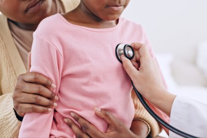 Closeup, child and stethoscope for examination in home for health, wellness or care. Medical professional, doctor and listen to heart, lungs or breathing for illness, virus and respiratory system