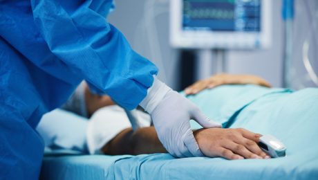 Holding hands, healthcare and a doctor with a patient in surgery for pulse, help or support. Hospital, medicine and closeup of a surgeon in theater with a person for consultation or medical nursing