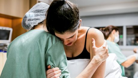 Doula helping pregnant women during birth at hospital